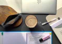 an open laptop computer sitting on top of a desk next to a notebook and pen