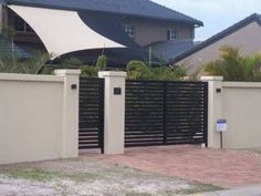 a fence that is next to a house with a white awning on top of it