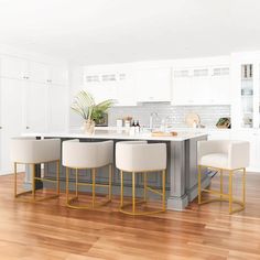 a kitchen with white cabinets and yellow barstools in front of an island counter