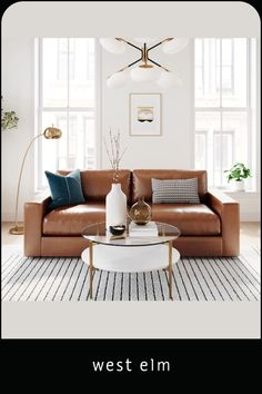 a living room with a couch, table and two lamps on the wall above it