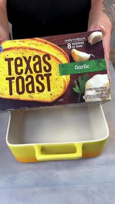 a person holding a box of texas toast with garlic in it's bottom and inside