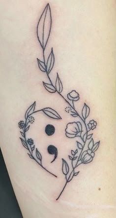 a small tattoo with flowers and leaves on the side of a woman's leg