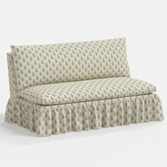 a couch with a ruffled skirt on it's back and the seat upholstered