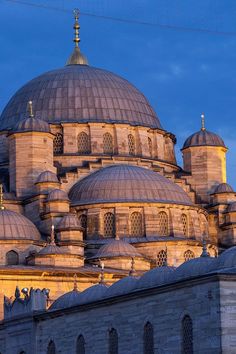 a large building with many domes on it's sides at sunset or twilight time