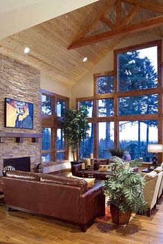 a living room filled with lots of furniture next to a fire place and large windows