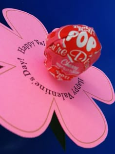 a pink flower shaped lollipop with the words happy valentine's day on it