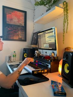 a man sitting at a desk in front of a computer with sound equipment on it