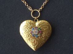 The romantic fashion for acrostic jewellery began in the Georgian period and continued through to the Victorian period. Sentimental messages such as 'love', 'regard' or 'dearest' could be spelled out by the first letter of each gemstone. The design for this pendant has been taken from an acrostic necklace found on an antique jewellery website. A working gold plated heart shaped locket is ready for your precious photos. The heart has a chased pattern of scrolls on the front while the reverse is p Brown Aesthetics, Jewellery Website, Heart Shaped Locket, Romantic Fashion, Victorian Period, Jewelry Website, Buy Buy, Pretty Earrings, Crystal Embellishment