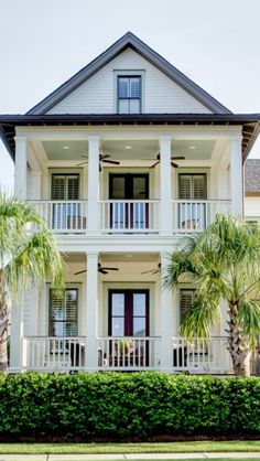 a large white house with palm trees in front