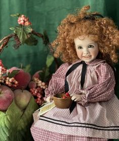 a doll with red hair holding a bowl of fruit