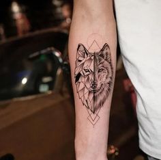 a man's arm with a tattoo of a wolf on the left side of his arm