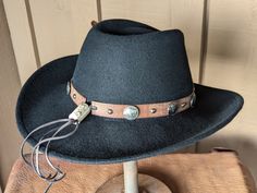 This 100% wool felt fedora is classically styled. Ready for your outdoor adventure! Perfect styling for a man or a woman. The distressed leather hatband has replicated Buffalo Nickel Conchos. The back of the band has a deer antler bead. Finished a feather detail. Water resistant and crushable.The brim is 3.5" and the crown is 4.5" Note: Hats are made to order. Allow up to 4 weeks for your hat to ship Adjustable Felt Hat With Flat Crown For Outdoor, Adjustable Wool Country Hat Bands, Rugged Adjustable Fedora For Western-themed Events, Adjustable Western Felt Hat For Outdoor, Country Style Adjustable Wool Hat Bands, Adjustable Wool Hat Bands In Country Style, Country Style Fur Felt Hat Band For Outdoor, Western Wool Hat Bands For Ranch, Adjustable Flat Brim Felt Hat For Riding