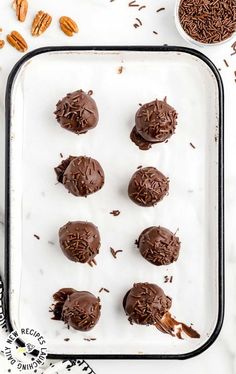 chocolate truffles on a baking sheet with nuts and pecans in the background