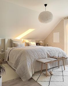 a bedroom with a large bed and white carpeted flooring next to a window