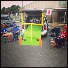 some people sitting in chairs near a van