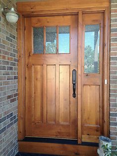 a wooden front door with two sidelights