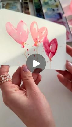 someone is painting hearts on a piece of paper