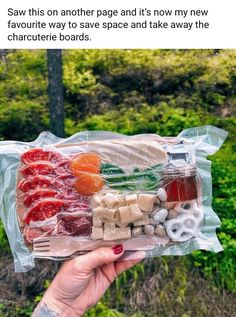 someone is holding up a plastic bag filled with different types of cheeses and fruit