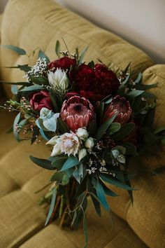 a bouquet of flowers sitting on top of a couch