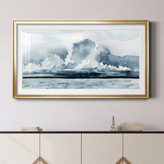 a painting hanging on the wall above a cabinet in a room with white walls and gold trim