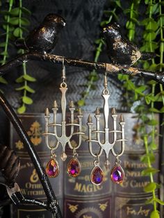 🕯️ HAUNTED CHANDELIER EARRINGS 🕯️ The Haunted Chandelier Earrings feature silver metal findings and color-shifting glass charms. * MATERIALS * Each piece at Nighthawk Jewelry is made up of a combination of materials, including: - Stainless Steel - Silver-plated metal - Gold-plated metal - Rose gold-plated metal - Rhodium - Iron - Brass - Assorted crystals (some items may differ in appearance due to natural variations) Disclaimer: Because every piece is made of a different combination of materials, Nighthawk Jewelry cannot ensure that any specific piece is made without one or more of the items listed above. If you are sensitive or allergic to any of the materials listed above, we advise you to err on the side of caution when purchasing or wearing anything from this shop. Everything is NIC Chic Metal Chandelier Earrings, Vintage Festive Metal Chandelier Earrings, Ornate Chandelier Earrings, Ornate Metal Chandelier Earrings, Festive Nickel-free Metal Chandelier Earrings, Chandelier Earrings, Rose Gold Plates, Jewelry Care, Metallic Silver