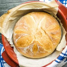 a loaf of bread sitting in a red bowl