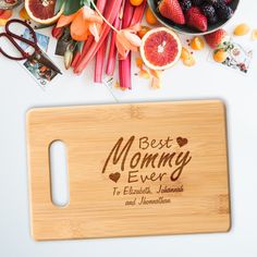 a cutting board with the words best mommy ever on it surrounded by fruits and vegetables