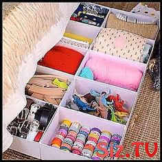 an open drawer filled with lots of crafting supplies on top of a rug next to a bed