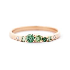 a gold band with green and white stones on the side, set in 18k rose gold