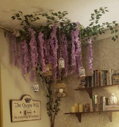 purple wister hanging from the ceiling in a room with bookshelves and shelves