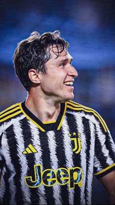 a soccer player is smiling and looking to the side with his head tilted back, wearing a black and white striped shirt