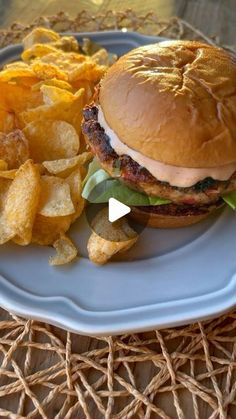 a hamburger and potato chips on a plate