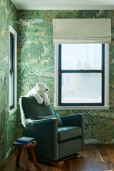 a chair with a stuffed animal on it in front of a wallpapered room