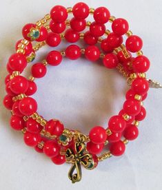 "This 5 decade Rosary bracelet is constructed with 8mm red beads, bamboo coral (dyed).   The Our Father beads are made up of Millefiori beads.  The beads are separated with iridescent pinkish-red seed beads.   The Rosary starts with a brass metal cross and finished with a gold colored, metal Miraculous Medal. The bracelet diameter is about 2.5\" - 3\" in resting state and can expand on wrist. The rosary bracelet is great to wear to work, school, church, parties or anywhere. It fits all sizes of Millefiori Beads, Red Bamboo, Decade Rosary, Bamboo Coral, Pinkish Red, Metal Cross, Rosary Bracelet, Red Beads, Miraculous Medal