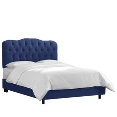 a bed with a blue headboard and white sheets