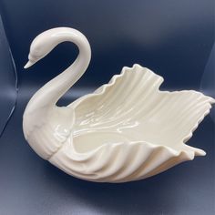 a white swan shaped bowl sitting on top of a table