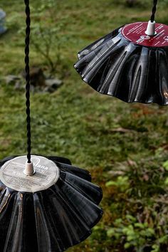 two black and red umbrellas hanging in the air with hearts attached to them,