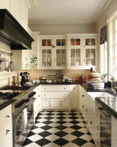 a kitchen with black and white checkered flooring on the walls, cabinets and counters