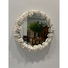 a round mirror hanging on the wall above a table