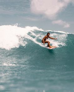 a man riding a wave on top of a surfboard in the middle of the ocean