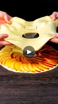 two hands holding a yellow mask on top of a wooden table