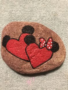 a rock painted with minnie and mickey mouse's hearts on top of a towel