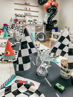 black and white checkered table cloths with party hats on them at a race themed birthday party