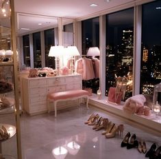 a room filled with lots of different types of clothes and shoes on display in front of large windows