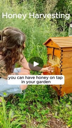 a woman kneeling down next to a beehive