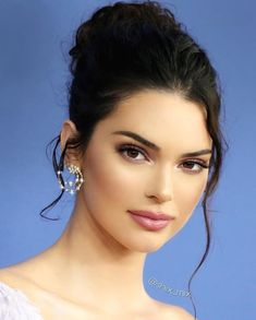 a close up of a person wearing earrings and a white dress with hair in a bun