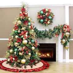 a decorated christmas tree sitting on top of a wooden floor next to a fire place