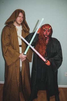 two people dressed up as darth vader and obi - wana, one with long red hair