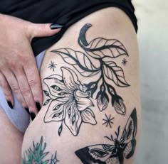 a woman's thigh with tattoos on it