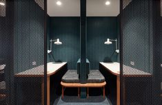 two sinks and mirrors in a bathroom with green walls, blue carpeted flooring